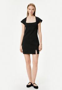 Schwarzes Minikleid mit quadratischem Ausschnitt, kurzen Ärmeln und seitlicher Schlitze. Es besteht aus glattem Stoff und bietet eine taillierte Silhouette.