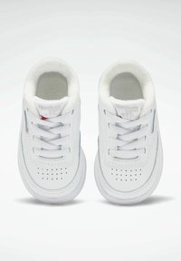 Baskets blanches avec bout perforé, tige en cuir lisse, col rembourré et lacets blancs. Présentent le logo Reebok sur la languette.