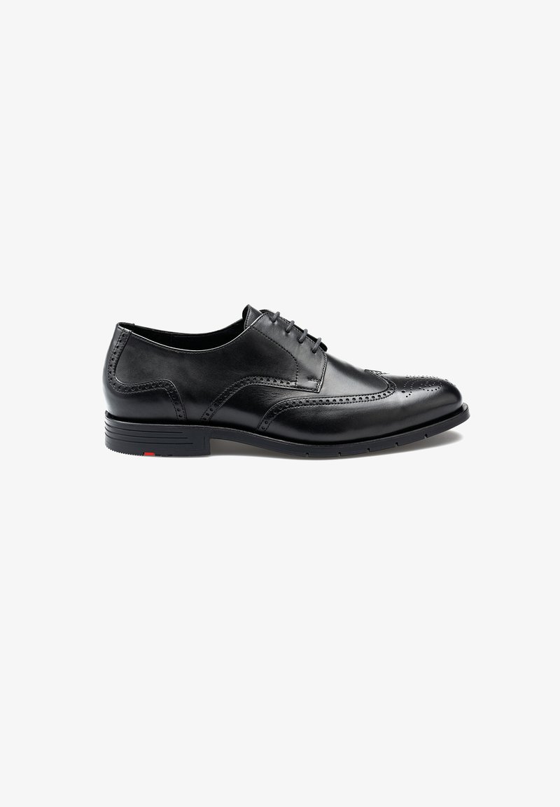 Zwarte leren geklede schoen met een ronde neus, brogue-details en vetersluiting. Heeft een gestructureerde buitenzool en een minimale rode accent.
