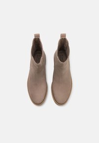 Bottes chevilles beiges en suède, avec une texture lisse, des panneaux latéraux élastiques et une semelle contrastante cousue.