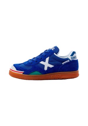 Zapatilla deportiva azul con logo blanco "X", detalles en rojo y verde, suela marrón y marca "Munich" en el talón y el lateral de la suela.