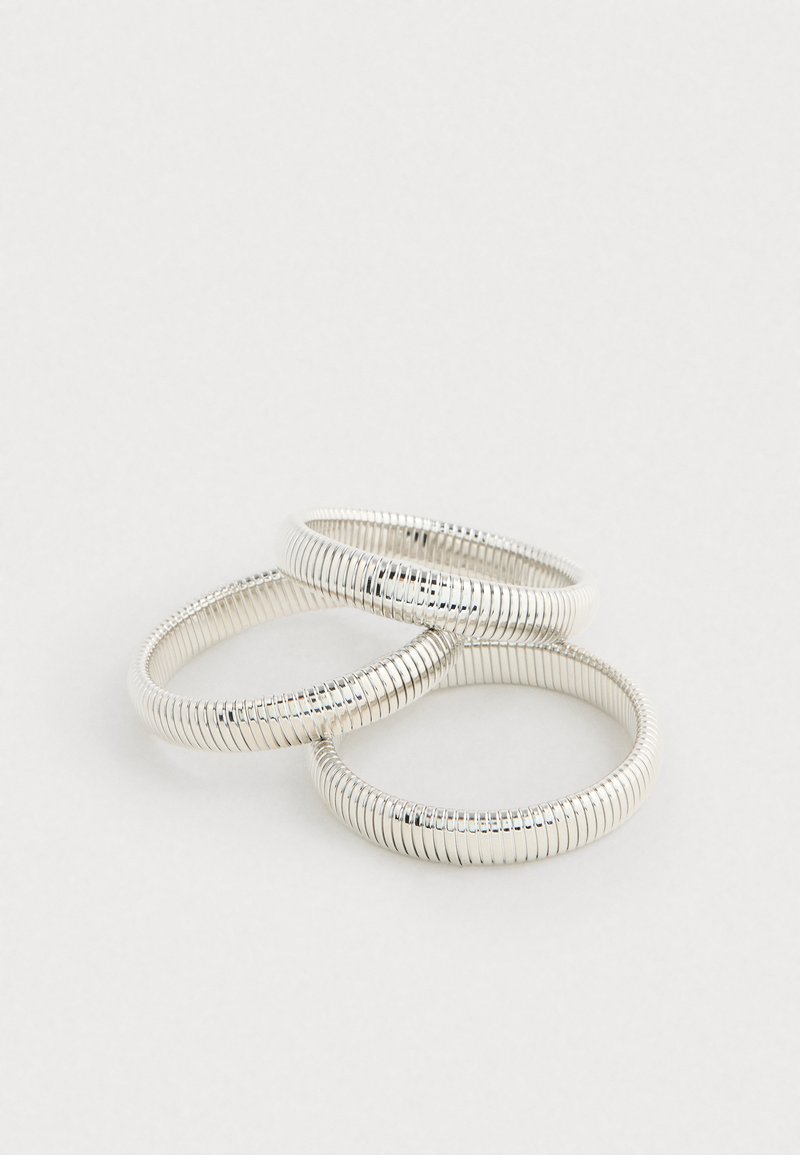 Sada troch strieborných prstencov tvarovaných ako pružiny, so hladkým povrchom a jednotným vzorom, s lesklým povrchom, ktorý zvýrazňuje ich dizajn.