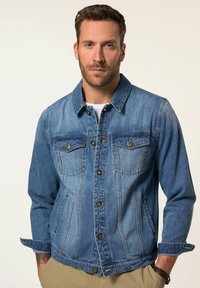 Denimjacka i medelblått, med knäppning, två bröstfickor och klassisk krage. Manschetter på ärmarna och avslappnad passform.