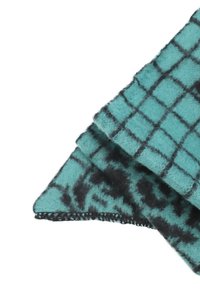 Coperta in lana con motivo turchese e nero, caratterizzata da un design a griglia, morbida al tatto e con bordi cuciti in nero. Due angoli sono ripiegati.