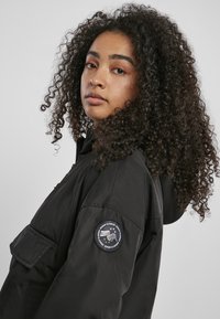 Urban Classics LADIES LONG OVERSIZED PULL OVER JACKET - Short coat - black