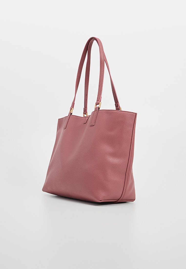 Sac fourre-tout en cuir rose avec une texture lisse, deux poignées pour l'épaule et un design structuré. Présente des accents en métal doré.