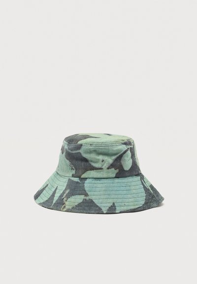 Κάπα με φαρδύ γείσο σε πράσινο και σκούρο γκρι σχέδιο tie-dye, απεικονίζεται σε απλό φωτεινό φόντο.