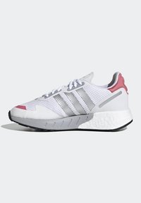 Vita sportskor i vitt med silverränder och en rosa detalj på hälen. Ovan del i mesh, texturerad grå mellansula och svart sula.