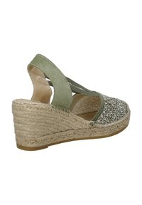 Sandalo con zeppa in suede verde e tacco in juta intrecciata. Design aperto, cinturini elastici e tessuto testurizzato sulla zona delle dita. Fodera interna morbida.