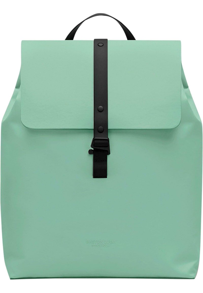 Mintgroene rugzak met klepafsluiting, zwarte strap en gesp, gladde textuur en een minimalistisch ontwerp. Merkenlogo aan de onderkant gedrukt.