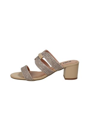 Sandale mule beige à bout ouvert avec un talon bloc et trois brides texturées scintillantes sur le pied.