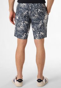 Marineblaue und graue Shorts mit einem blätterartigen Muster, aus einem strukturierten Stoff gefertigt. Verfügt über Gesäßtaschen und eine taillierte Passform. Getragen mit lässigen Schuhen.