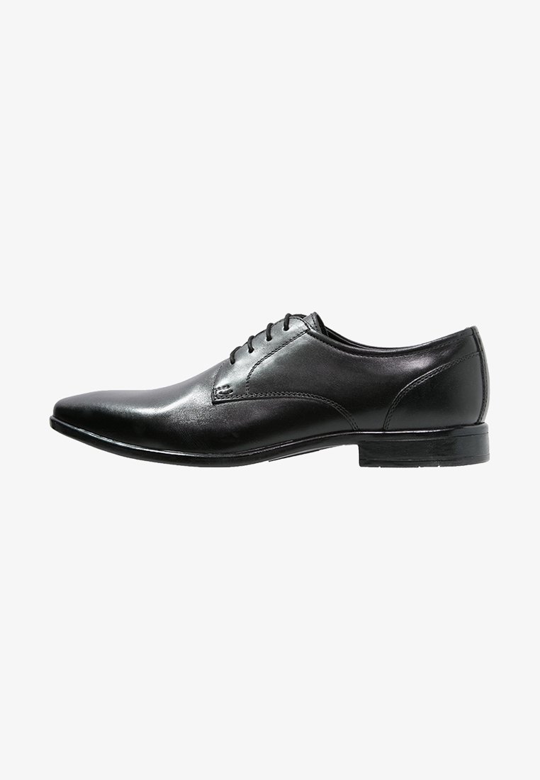 Chaussure habillée pour homme en cuir noir, bout pointu, fermeture à lacets et talon bas empilé, vue de profil sur fond blanc.