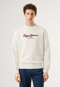 Sudadera de color crema hecha de tejido, con cuello redondo, puños acanalados y un logo bordado en granate que dice "Pepe Jeans London."