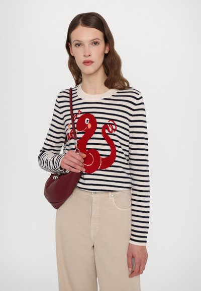 Striped sweater with red octopus design, made of knit material. Features navy and cream stripes, crew neckline, and fitted cuffs. Beige pants and burgundy handbag.