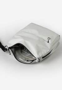 Grijze nylon tas met een ritssluiting, voorzien van zwarte hardware en binnenzakken. Gladde textuur, rechthoekige vorm, verstelbare schouderband.