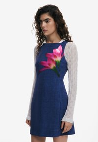 Rochie albastră texturată cu imprimeu floral, având flori roz pe față. Mâneci lungi din material transparent alb, cu dungi verticale.