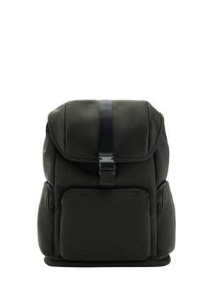 Mochila negra con una solapa superior asegurada con una hebilla, un bolsillo frontal con cremallera y dos bolsillos laterales con cremallera, apoyada en posición vertical sobre un fondo blanco.
