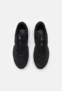Scarpe atletiche nere in rete con suola bianca, caratterizzate da un logo accentato rosa e un design con lacci, per una calzata leggera e traspirante.