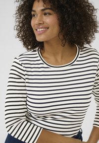 Striped long-sleeve top in white and navy, featuring a round neckline and fitted sleeves, made of soft fabric with a smooth texture.