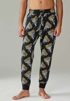 Schwarze Schlafanzuhosen im Nirvana-Stil. Mit gelben und grauen Grafikdrucks, elastischem Bund und elastischen Bündchen an den Knöcheln. Glatte Textur.