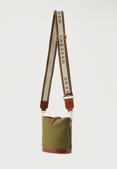 Πράσινη τσάντα τύπου κάδος με καφέ δερμάτινη επένδυση και φαρδιά ρυθμιζόμενη λουρίδα με την ένδειξη "WEEKEND" σε πράσινο, μπεζ και καφέ χρώμα.
