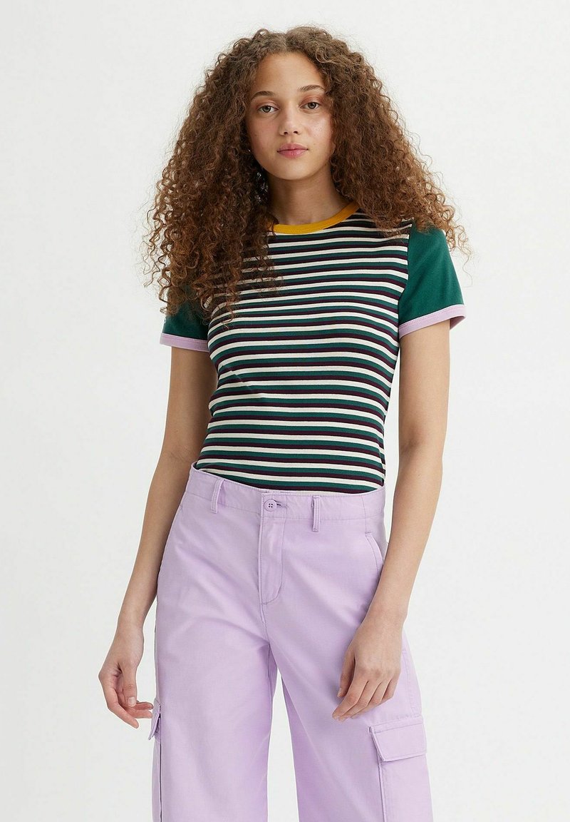 Gestreiftes T-Shirt in Grün, Lila und Gelb, mit kurzen Ärmeln und rundem Halsausschnitt. Kombiniert mit hell-lila Cargo-Hosen.