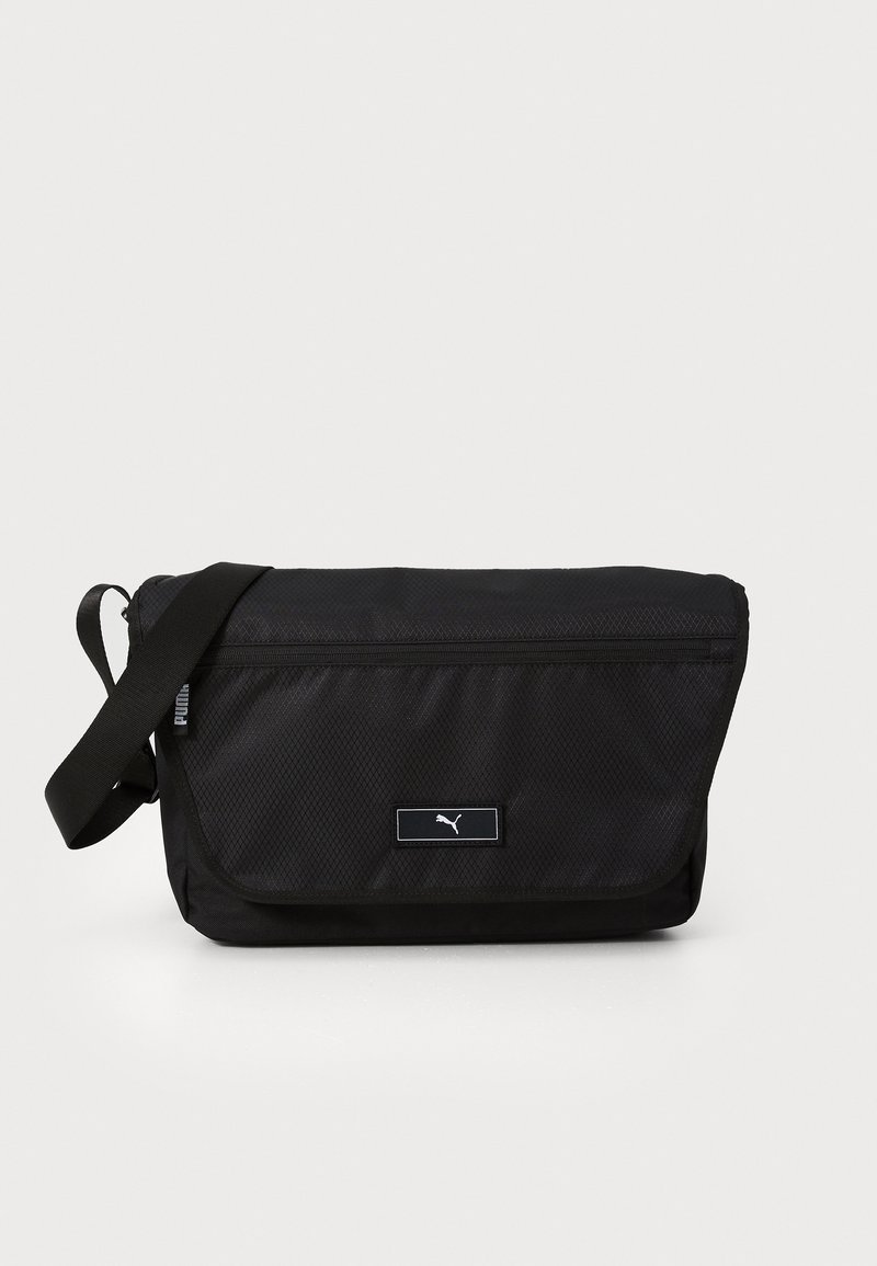 Sac messager noir en nylon texturé avec une fermeture à rabat, une bandoulière ajustable et un patch logo à l'avant.