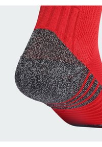 Κόκκινη πλεκτή κάλτσα με γκρίζα, υφασμάτινη φτέρνα και ραμμένο σχέδιο, που διαθέτει ομαλή μετάβαση μεταξύ των χρωμάτων και σχήμα που κολλάει στο πόδι.