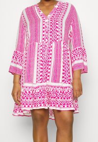 Vestido rosa con estampado en corte A, escote en V, mangas acampanadas de tres cuartos y diseños geométricos. Confeccionado en tejido ligero.