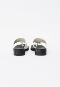 Svartvitrutiga sandaletter med en minimalistisk design, som har ett mjukt material, breda remmar, en formad fotbädd och en blockklack.