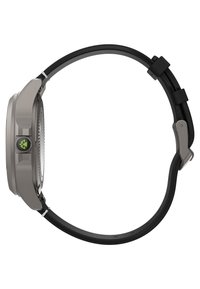 Reloj deportivo gris con una cara redonda, correa de goma negra, detalles negros y un botón verde prominente en el lado. Diseño minimalista.