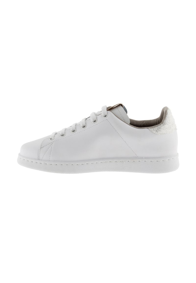 Zapatilla blanca de cuero con un respaldo texturizado, punta redondeada y suela de goma plana. Presenta seis ojales y un diseño minimalista.