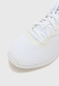 Adidași albi cu un exterior din plasă texturată, având un accent neted și sireturi plate. Vârf curbat și design cu talpă căptușită.