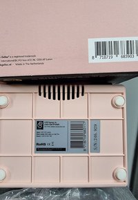 LED UV-lamp in roze plastic, rechthoekig ontwerp met afgeronde hoeken. Bevat een grijze label met specificaties en vier witte voetjes aan de onderkant.