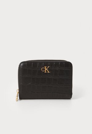 Black crocodile-patterned zip wallet with gold cK logo and gold zipper pull on a white background.