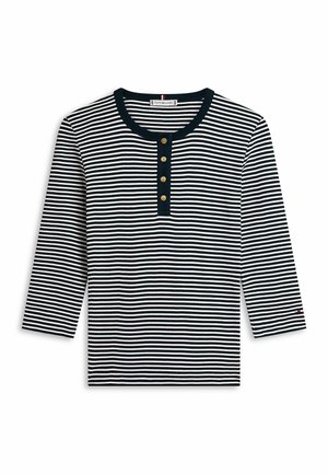 Marineblaue und weiße horizontal gestreifte Langarmshirt mit rundem Ausschnitt und vier goldenen Knöpfen auf einer schwarzen Blende.