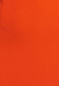 Helle orangefarbene Stoff mit glatter Textur und matter Oberfläche, der eine gleichmäßige Farbausweisung ohne erkennbare Muster oder Details aufweist.