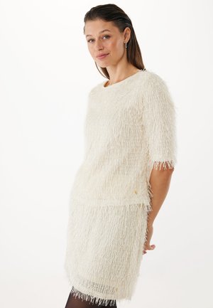 Vestido texturizado blanco y esponjoso con mangas cortas, que presenta un corte recto y sutiles detalles dorados. Forro interior suave.