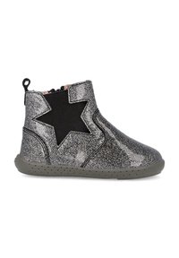 Botín brillante plateado con panel lateral elástico negro y acento de estrella. Parte superior texturizada y suela de goma gris con pequeños puntos para un mejor agarre.