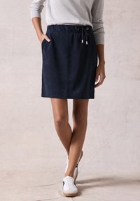 Marineblauer, knielanger Rock aus weichem Stoff mit einem elastischen Bund und Kordelzug sowie seitlichen Taschen. Glatte Textur.