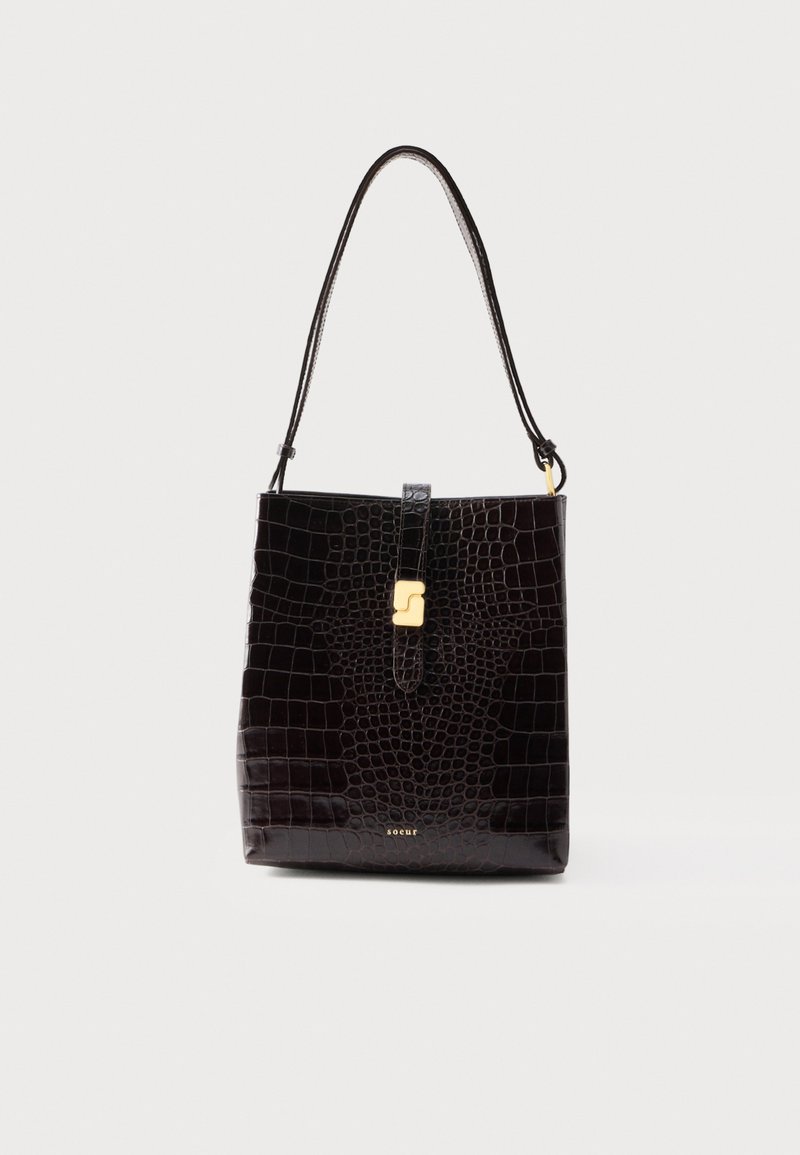 Μαύρη τσάντα ώμου από δέρμα με υφή κροκόδειλου, με έναν ιμάντα και χρυσή αγκράφα μπροστά.