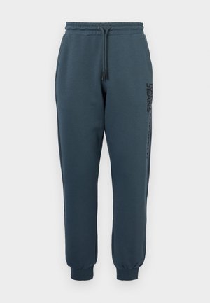 Temno modri športni hlače iz mešanice bombaža. Imajo elastični pas z vrvico in rebraste manšete. Stranski detalj s توقيتom.