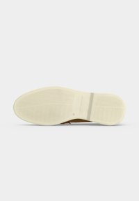 Σόλα ανδρικού καφέ δερμάτινου παπουτσιού με κρεμ εξωτερική σόλα από καουτσούκ που διαθέτει κυματιστά μοτίβα πέλματος και χαραγμένο το όνομα της μάρκας "Tommy Hilfiger."