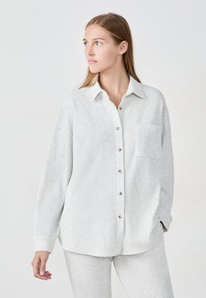 Button-up shirt in light gray ribbed fabric, featuring a collar, long sleeves, and a chest pocket with a relaxed fit design.