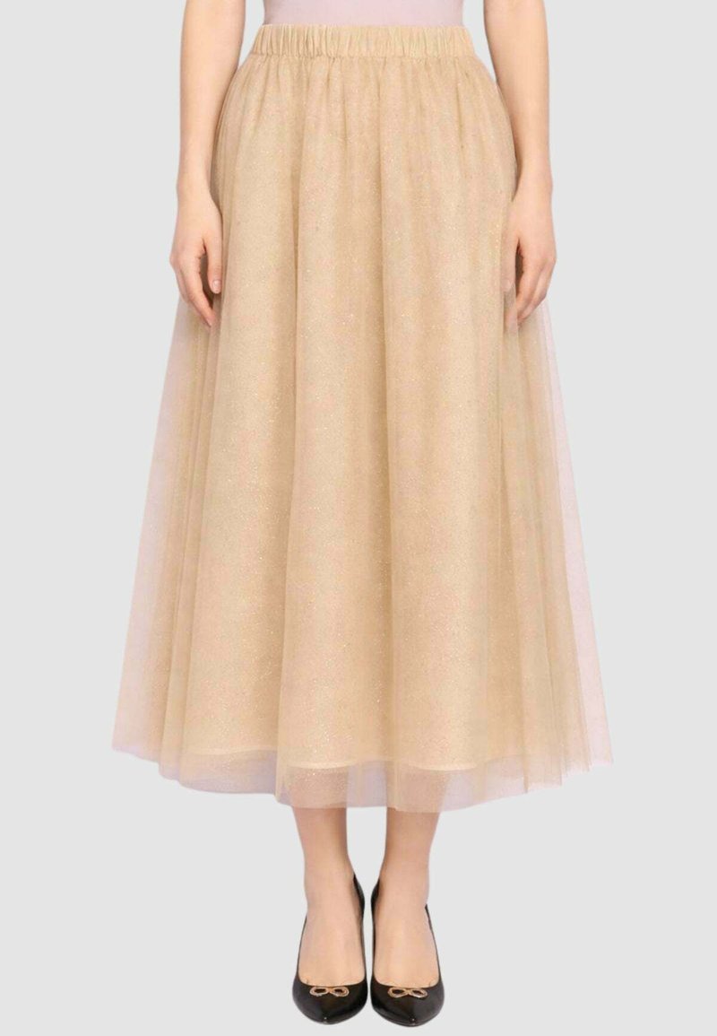 Gonna in tulle beige con cintura elastica, lunghezza al ginocchio con texture a strati, finitura luminosa, abbinata a ballerine nere.