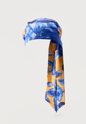 Jedwabna chusta z niebieskimi wzorami kwiatowymi na żółtym tle, luźno związana z długimi zwisającymi końcami.