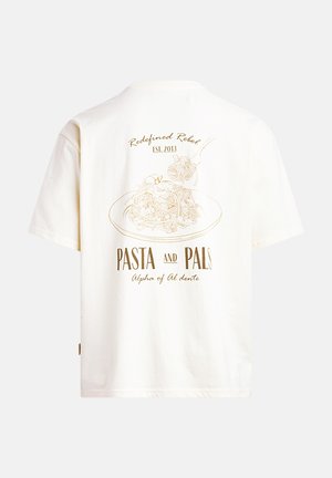 T-shirt en coton couleur crème à manches courtes. Il présente un graphique doré de pâtes sur une assiette et le texte "Pasta and Pals" au dos.