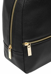 Czarny plecak z fakturowanej skóry w okrągłym kształcie. Posiada złote zamki i akcesoria, z wyraźnym detalem zamka po boku.