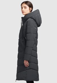 Pikk must puffer jope kapuutsiga, millel on tikandid, tõmblukk ja küljetaskud, loodud soojust ja mugavust silmas pidades.